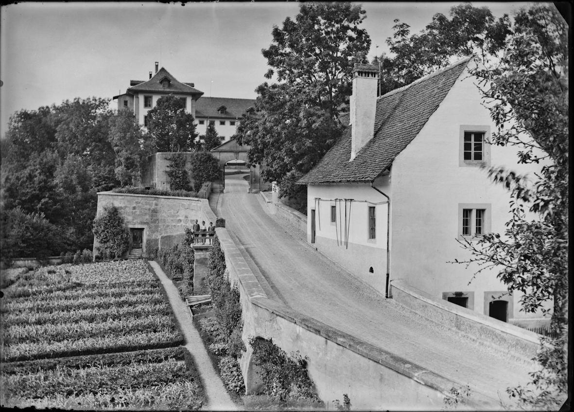 Straf- und Verwahrungsanstalt Thorberg, Krauchthal; die Gärtnerei und das Glauserhüsi und die Zufahrtsstrasse, im Hintergrund das Tor und der Thorberg