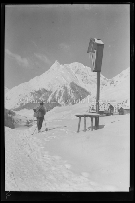 Wegkreuz, Dorf im Tal von Samnaun, mit Skifahrer
