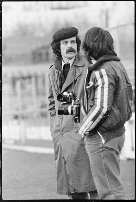 zwei Fotografen mit umgehängten Fotoapparaten auf einem Fussballfeld stehend, links der Fotograf Eduard Rieben