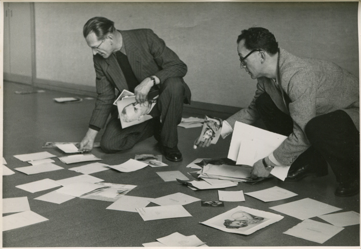 Albert Tschopp (l.; 1892-1965) und Jacques Weiss (r.; 1904-1989) legen Fotos auf dem Boden aus