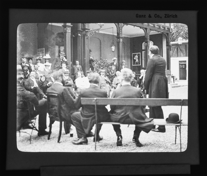 Mitglieder des Schweizer Photographen Vereins sitzen im Halbkreis auf einem Vorplatz