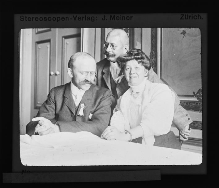 Zwei Mitglieder des Schweizer Photographen Vereins mit einer Frau am Tisch