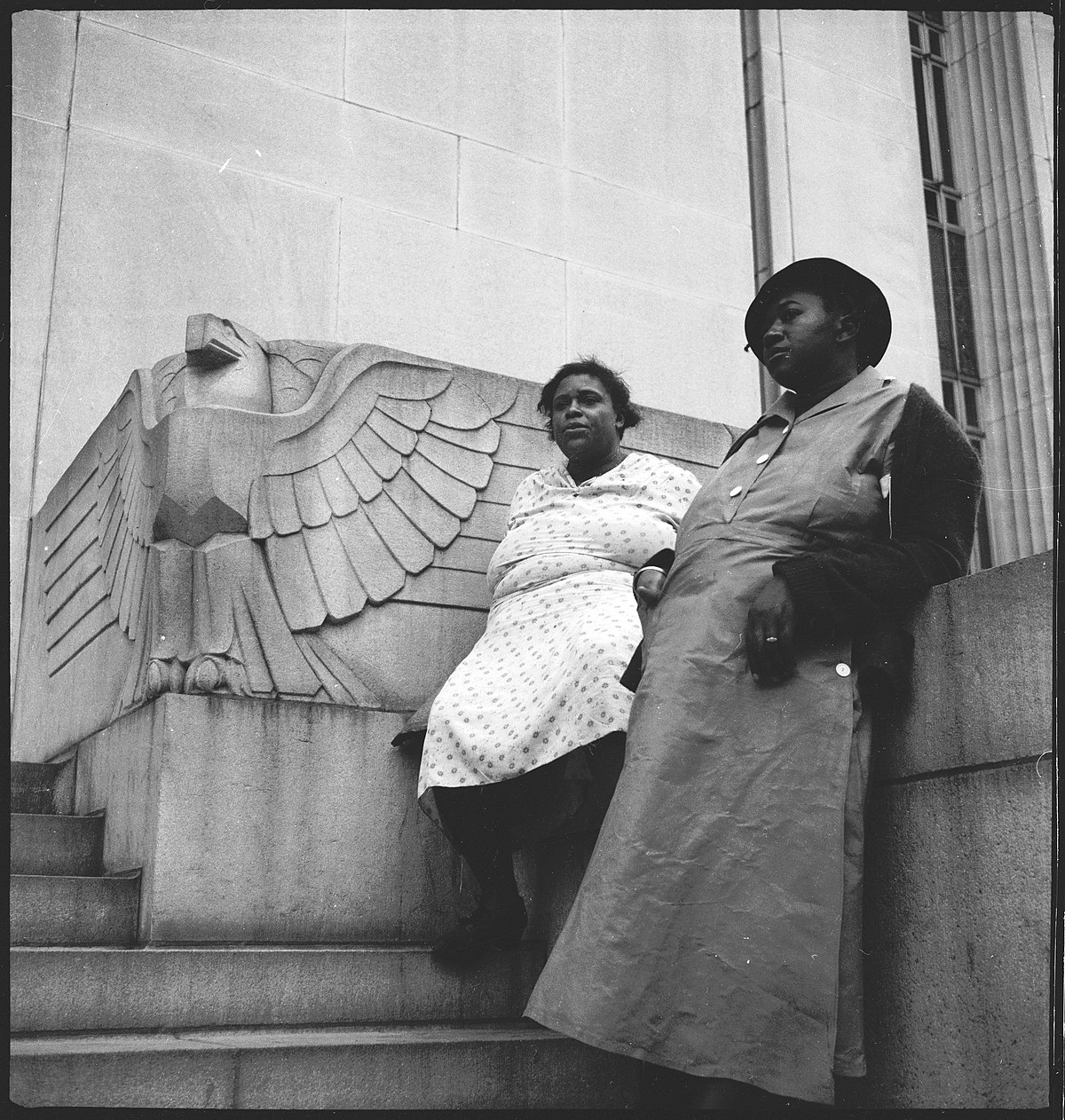 USA: Menschen; Zwei Frauen vor einem Adler-Relief auf einem Treppenaufgang zu einem Gebäude