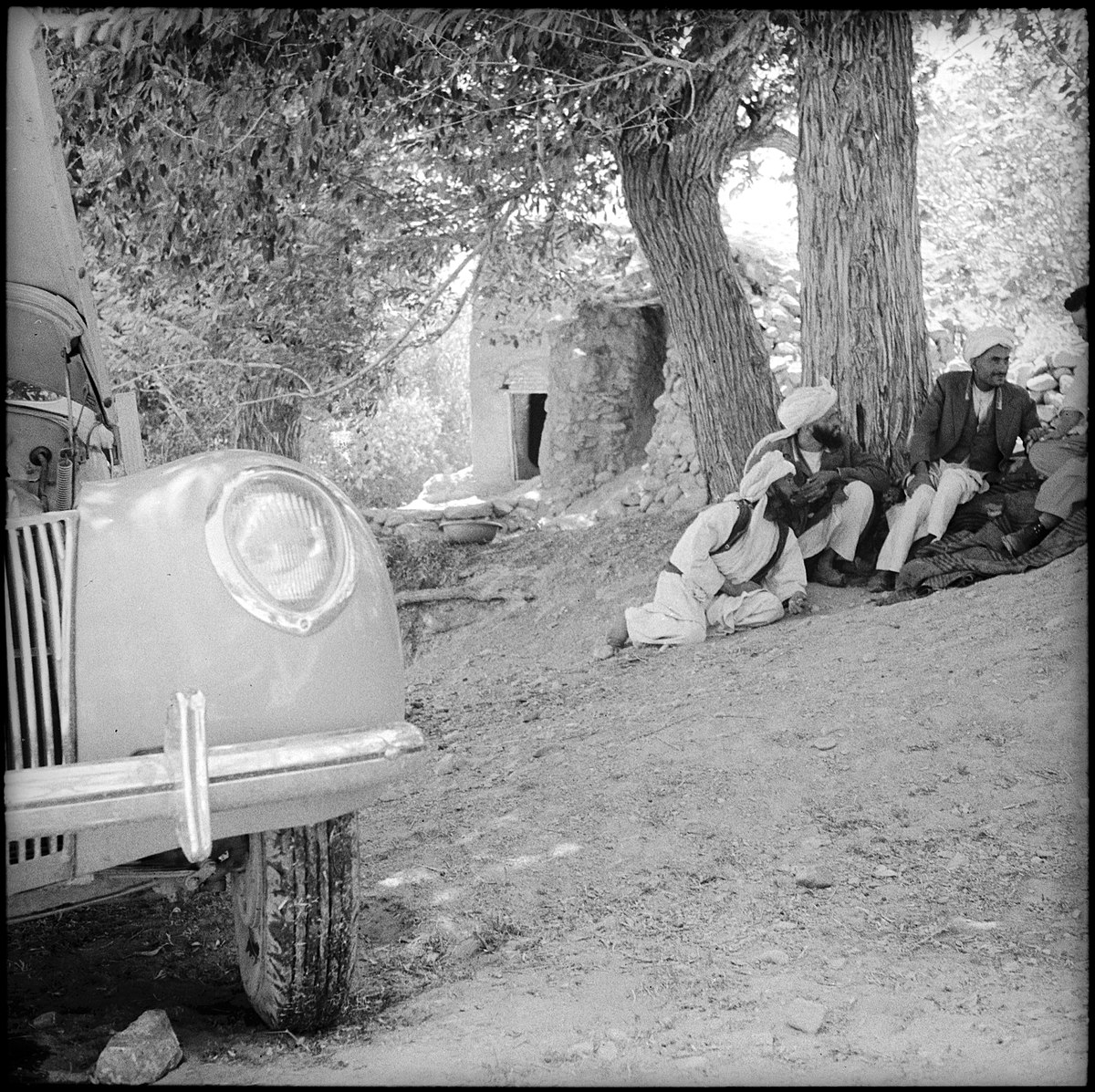 Afghanistan, Chahrshambe (Khvajeh Chahar Shanbeh): Menschen; Männer sitzend unter einem Baum, im Vordergrund der Ford