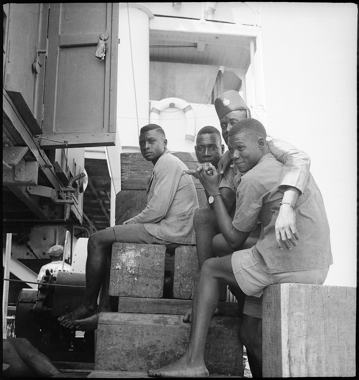 Belgisch-Kongo, Fluss Kongo: Soldaten; Vier farbige Soldaten sitzen barfuss zusammen auf dem Deck
