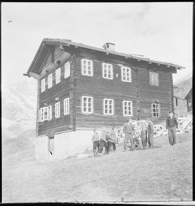 Jungen vor Holzhaus