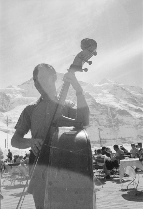 Musiker mit Bassgeige auf der Sonnenterrasse des Hotels Bellevue des Alpes