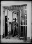 Straf- und Verwahrungsanstalt Thorberg, Krauchthal; Aufseher stehend im Zellengang 3. Stock, Zellenbau