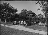 Straf- und Verwahrungsanstalt Thorberg, Krauchthal; Hof im Bannholz, umgeben von Bäumen, zuführender Weg, zwei Knaben beim Schwingen, ein Knabe, ein Mädchen und ein Mann schauen zu