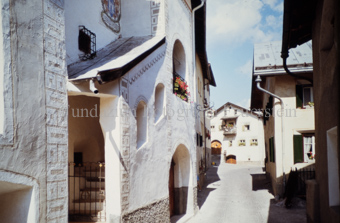 Gasse im Dorf, geschützte Aussentreppe, Fassade mit Sgraffito und Wappen