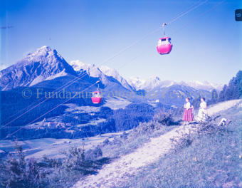 Vulpera im Hintergrund, zwei Frauen flanieren unter der Bahn