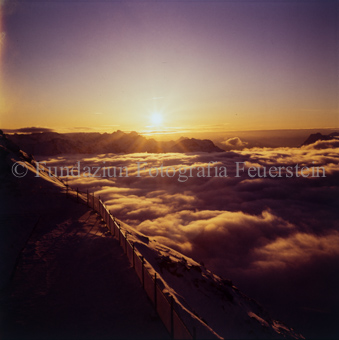 Sonnenuntergang über den Gipfeln über der Wolkendecke