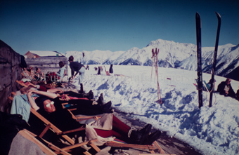Personen auf Sonnenterrasse neben Skipiste