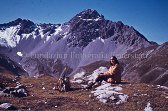 Frau auf Felsen, Rucksack am Boden