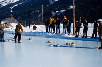 Curlingspieler und Zuschauer auf Eisfeld