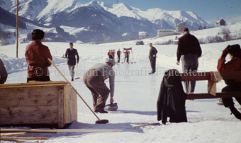 Curlingspieler und Zuschauer auf Eisfeld
