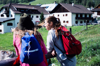 Zwei Frauen mit Rucksack vor Dorf