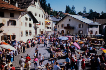 Dorfplatz, viele Personen auf dem Markt