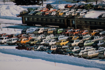 Parkplätze und Zug beim Bahnhof Scuol im Winter