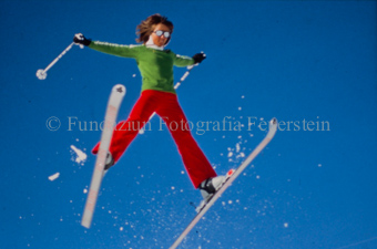 Skiakrobatin im Sprung mit gespreizten Ski