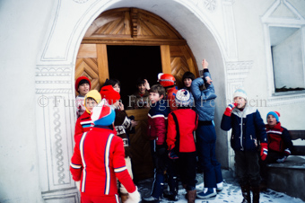 Kinder vor dem Tor, Knabe im Guckloch mit Geschenk