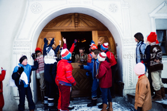 Kinder vor dem Tor, Knabe im Guckloch mit Geschenk