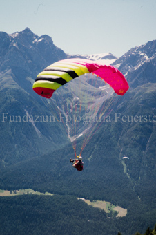 Gleitschirmflieger in der Luft vor Berglandschaft