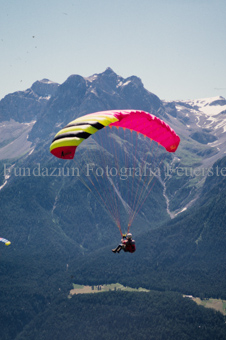 Gleitschirmflieger in der Luft vor Berglandschaft