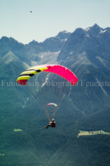 Gleitschirmflieger beim Start vor Berglandschaft