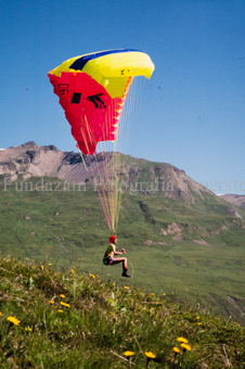 Gleitschirmflieger beim Start vor Berglandschaft