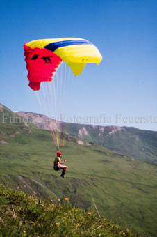 Gleitschirmflieger beim Start vor Berglandschaft