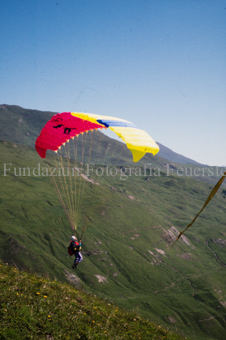Gleitschirmflieger beim Start vor Berglandschaft