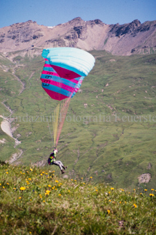 Gleitschirmflieger beim Start vor Berglandschaft