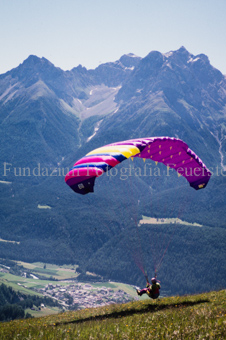 Gleitschirmflieger beim Start vor Berglandschaft