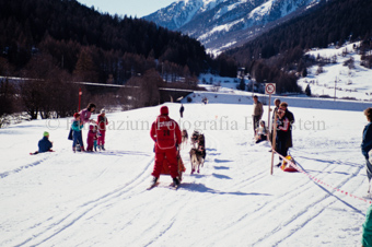 Alpirod Hundeschlittenrennen, Fahrer auf Schlitten mit Gespann bei Zuschauern