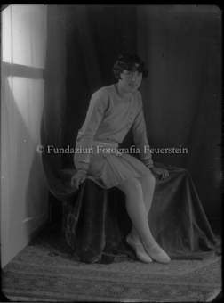 Junge Frau sitzend auf einer Stuhlinstallation mit Tüchern