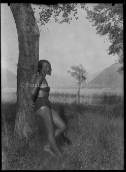 Frauenporträt im Badeanzug, an einem See, angelehnt an Baum