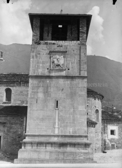 Gedrungener Turm mit offenem Dachgeschoss bei romanischer Kirche