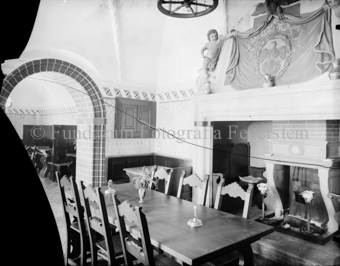Rustikales Interieur mit verziertem Kamin, Tisch und Stühlen