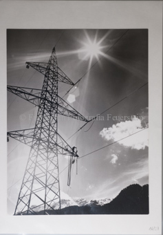 Hochspannungsmasten, Montage der Kabel, mit Wolken im Gegenlicht