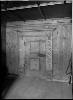Massive Holztür mit Innschrift und Gewehr