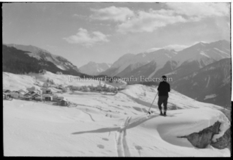 Skifahrer mit Ftan im Hintergrund