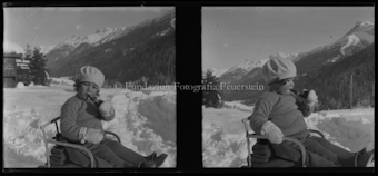 Kind mit Schlitten, Winter, im Hintergrund Schild von «Otto Lanz, Bergführer»