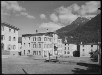 Dorfplatz mit Brunnen, im Hintergrund Hotel Linard