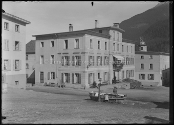 Dorfplatz mit Brunnen, im Hintergrund Hotel Linard