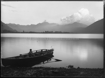 Junge in Ruderboot an Seeufer 