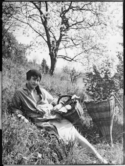 Frau mit Korb auf Feld liegend