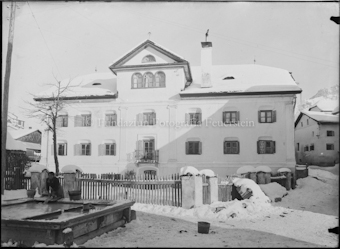 Grosses Wohnhaus hinter Brunnen im Winter