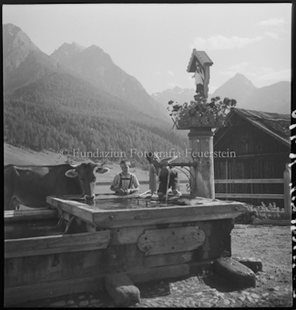 Bauer und Kuh am Brunnen