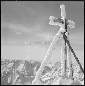 Verschneites Kreuz auf Berggipfel